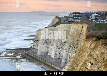 Maisons au bord de falaises de craie à Peacehaven, près de Brighton, UK, au coucher du soleil Banque D'Images