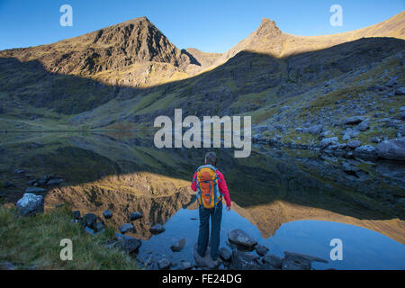 Walker et Lough Gouragh sous Carrauntoohil, Hag's Glen, MacGillycuddy Reeks, comté de Kerry, Irlande. Banque D'Images