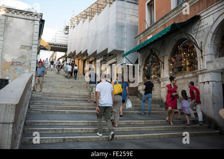 Les touristes magasinent sur les marches du Ponte Di Rialto (pont du Rialto) à Venise, en Italie. Le pont est en cours de re Banque D'Images