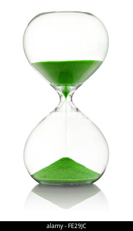 Sablier en verre avec du sable vert qui traverse la mesure de temps qui passe dans un compte à rebours jusqu'à une date limite, plus de blanc avec reflet Banque D'Images