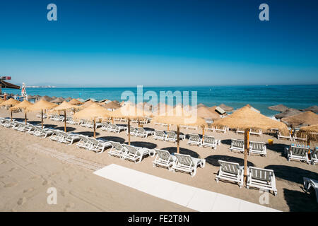 Plage des chaises longues au bord de la mer Méditerranée. Chaise-longues sur la plage. Transats et parasol sur la plage Banque D'Images