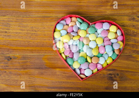 Boîte en forme de coeur rempli de petites boules de chocolats Banque D'Images