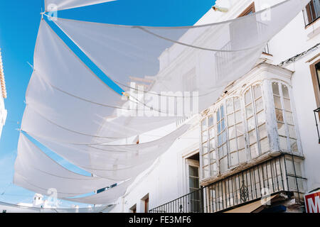 Ancien de l'architecture urbaine dans les étroites rues et confortable à Nerja, Espagne. Beau blanc balcon dans un immeuble. Ensoleillé couvert en tissu Banque D'Images