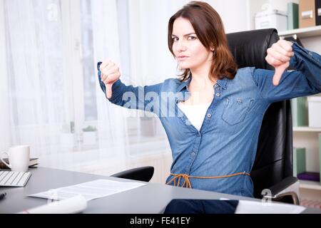 Businesswoman giving Thumbs down avec force geste avec les deux mains et les sourcils à l'appareil photo montrant la désapprobation, un échec Banque D'Images