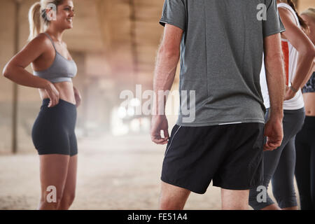 Cropped shot de jeunes prenant pause dans l'exécution de la formation. Les athlètes se détendre et parler après le jogging. Banque D'Images