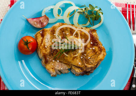 Côtelette de porc grillée avec des oignons et de la tomate, vue du dessus Banque D'Images