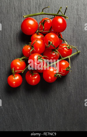 Tomates cerises sur une ardoise noire Banque D'Images