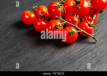 Tomates cerises sur une ardoise noire Banque D'Images