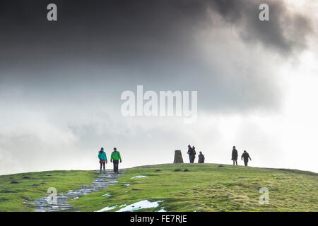 Les marcheurs à l'Trig point sur le haut de Mam Tor sur un jour d'hiver lumineux. Banque D'Images