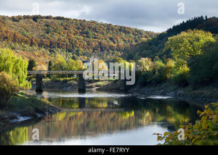 L'ancien pont ferroviaire Wireworks traversant la rivière Wye à Tintern avec les ruines de l'abbaye de Tintern en arrière-plan, Monmouthshire, Wales Banque D'Images