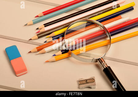 Crayon de couleur avec loupe sur table en bois gris Banque D'Images