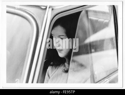 Jeune femme des années 60, des années 70 à l'intérieur d'une voiture Fiat vintage. Film en noir et blanc Banque D'Images