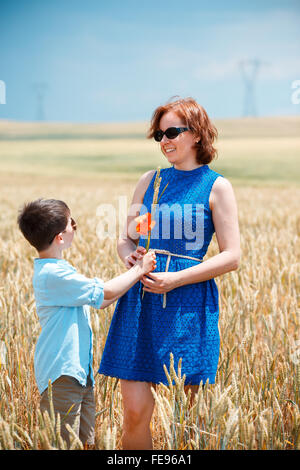 Heureuse fête avec petit-fils marcher joyeusement dans le champ de blé Banque D'Images