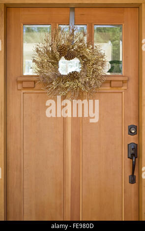 Belle couronne d'or sur la pendaison porte avant en bois. Simple, naturelle, élégante maison de vacances de Noël décorations. Banque D'Images