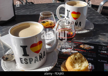 Deux grandes tasses à café espana avec un verre de brandy, Tia Maria et un gâteau Benidorm, province d'Alicante, Espagne Banque D'Images