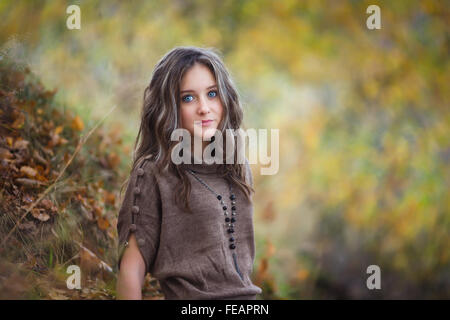 Portrait de belle jeune fille sur fond de feuilles jaunes Banque D'Images