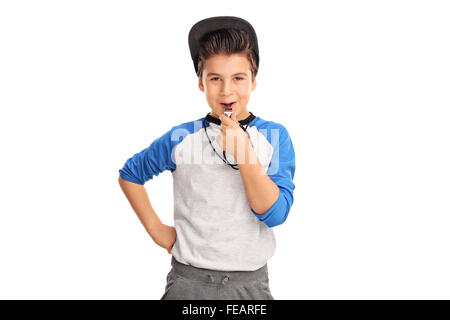 Garçon joyeux soufflage dans les vêtements de sport d'un sifflet et regardant la caméra isolé sur fond blanc Banque D'Images