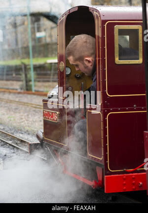 Chauffeur Hughes Douglas poignées sur le chemin de fer à Betws-Y-coed dans le Nord du Pays de Galles prêt à donner des excursions en train d'un autre groupe de c Banque D'Images