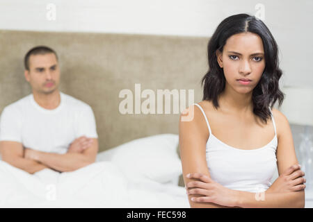 Contrariés couple sitting on bed après avoir un argument Banque D'Images