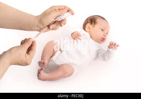 Pédiatre prêt à donner une petite fille d'un mois une injection intramusculaire dans la jambe. Se concentrer sur les mains. Banque D'Images