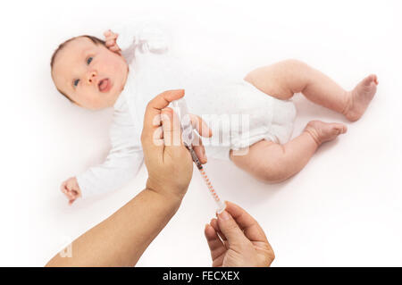 Pédiatre prêt à donner une injection de fille de bébé d'un mois. Se concentrer sur les mains. Banque D'Images
