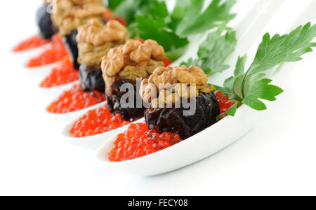 Les pruneaux farcis au pâté de foie avec les écrous dans un caviar rouge Banque D'Images