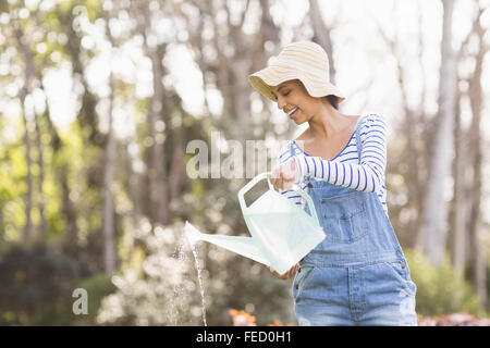 Smiling brunette l'arrosage des plantes Banque D'Images