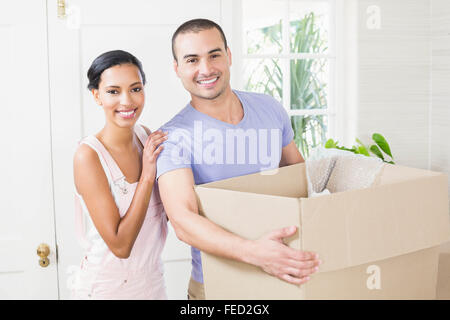 Heureux couple smiling with moving box Banque D'Images