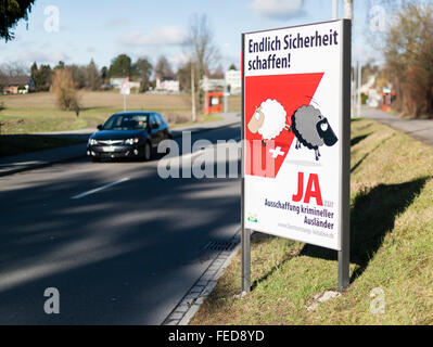 Affiche de campagne d'un référendum "pour le renvoi des criminels étrangers efficace' à côté d'une rue dans les régions rurales de la Suisse. Banque D'Images