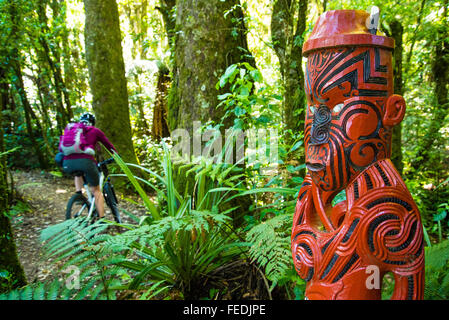 Du vélo de montagne et la sculpture maorie au début de la piste de bois dans le Parc Forestier de Pureora Ile du Nord Nouvelle Zélande Banque D'Images