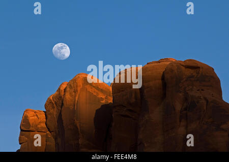 Les falaises en grès rouge au coucher du soleil avec la pleine lune dans le ciel, Monument Valley Navajo Tribal Park, Arizona, USA Banque D'Images