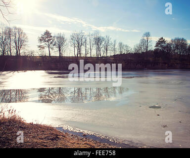 Paysage d'hiver en Bavière - lac avec vue partielle surface gelée et la réflexion sur la surface de l'arbre Banque D'Images