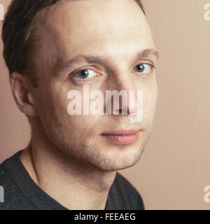 Young handsome man positive studio portrait sur fond de mur gris, vintage photo stylisée, filtre tonal rétro corr Banque D'Images