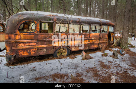 Rusty old school bus assis dans junkyard Banque D'Images