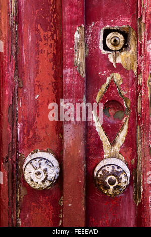 Vieille porte en bois grunge avec de la peinture et des poignées de porte rondes Banque D'Images