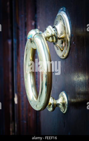 Détails d'un heurtoir laiton ronde sur une porte en bois, vue latérale. Banque D'Images