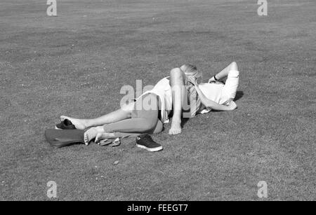 Les amateurs anonymes enlacés sur l'herbe dans un parc public. Juillet 2015 Banque D'Images