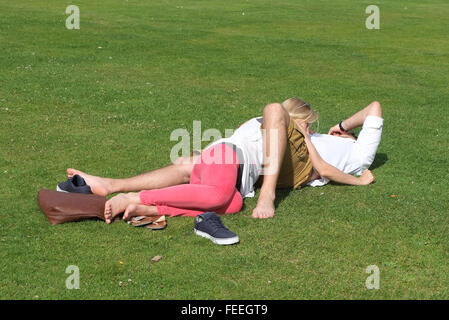 Les amateurs anonymes enlacés sur l'herbe dans un parc public. Juillet 2015 Banque D'Images