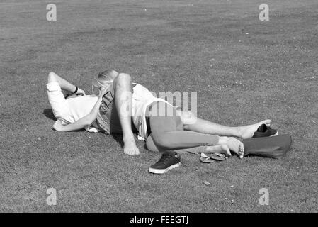 Les amateurs anonymes enlacés sur l'herbe dans un parc public. Juillet 2015 Banque D'Images