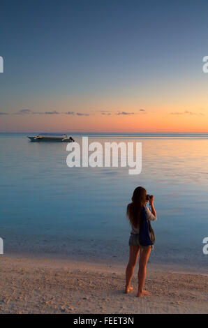 Woman taking photo sur la plage de Matira au coucher du soleil, Bora Bora, îles de la société, Polynésie française (MR) Banque D'Images