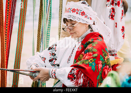 Gomel, Bélarus - 12 septembre 2015 : Femme en costume folklorique biélorusse national ceinture tissage Banque D'Images