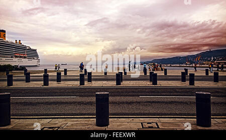 Trieste, Italie - promenade au bord de mer Le Rive au crépuscule avec personnes à pied et la gare maritime Banque D'Images