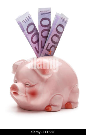 Pink piggy bank avec cinq cent billets, isolé sur le fond blanc, chemin de détourage inclus. Banque D'Images