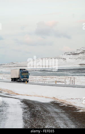 Conduite de camion le long de la route à travers les montagnes couvertes de neige en Islande en Février Banque D'Images