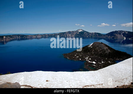 Une vue large de l'île de l'Assistant et le lac du cratère,avec de la neige à l'avant-plan et l'éparpillement de la neige sur certains des pics dans la caldeira Banque D'Images