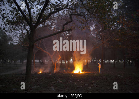 Dhaka, Bangladesh. Feb 6, 2016. DHAKA, BANGLADESH - 06 février : Les personnes prenant feu chaud de feuilles séchées à l'intérieur d'un soir d'hiver dans un parik à Dhaka, Bangladesh, le 06 février 2016. © Zakir Hossain Chowdhury/ZUMA/Alamy Fil Live News Banque D'Images