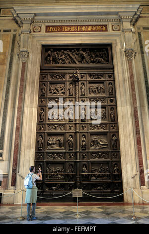 Un touriste photographie les portes de bronze, couverts en reliefs par Ivan Vitali, à l'intérieur de la Cathédrale St Isaac, St Petersbourg, Russie. Banque D'Images