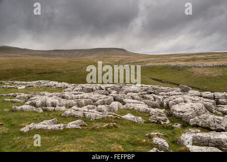 Le lapiez Ingleborough, Yorkshire, UK avec cavers à pied de Gaping Gill Banque D'Images