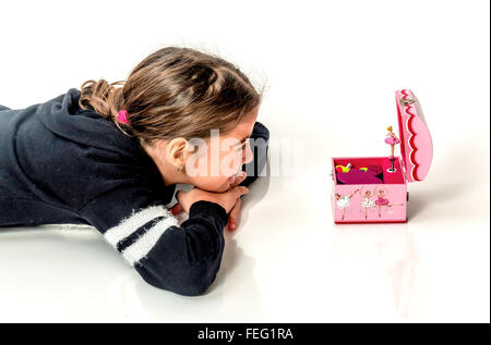 Happy little girl écouter la musique à partir de la boîte à musique avec ballerine isolated on white Banque D'Images