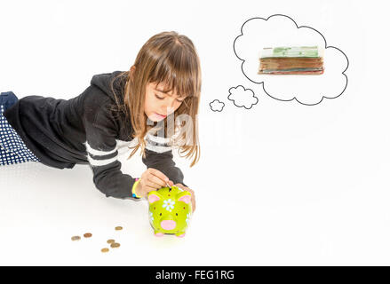 Petite fille d'économiser de l'argent dans la tirelire Banque D'Images